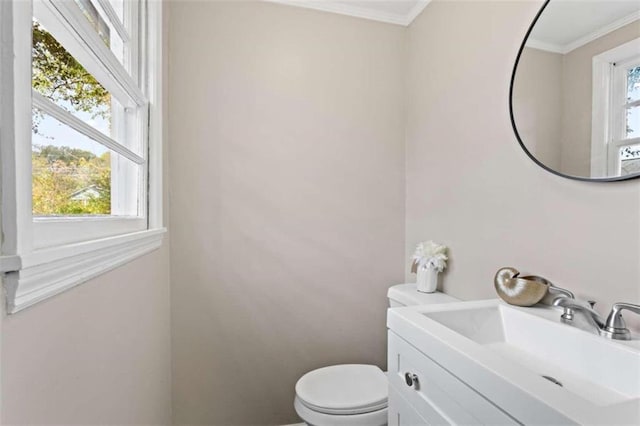 bathroom with crown molding, plenty of natural light, toilet, and vanity