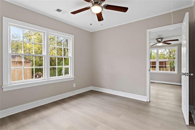 spare room with ceiling fan, a healthy amount of sunlight, and light wood-type flooring