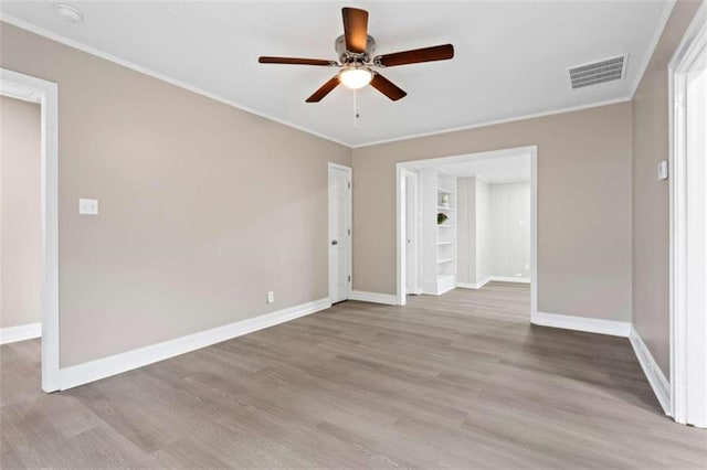 empty room with crown molding, ceiling fan, and light hardwood / wood-style flooring