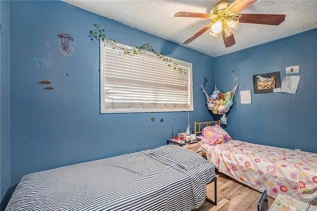 2087 Chestnut Way, Lithia Springs, GA 30122 - bedroom with wood finished floors, ceiling fan, and a textured ceiling