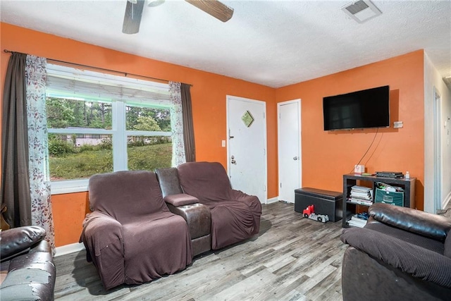 2087 Chestnut Way, Lithia Springs, GA 30122 - living area featuring wood finished floors, baseboards, a ceiling fan, and a textured ceiling