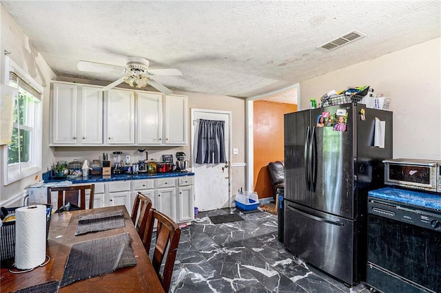 2087 Chestnut Way, Lithia Springs, GA 30122 - kitchen with freestanding refrigerator, white cabinetry, ceiling fan, dark marble finish floors, and dark countertops