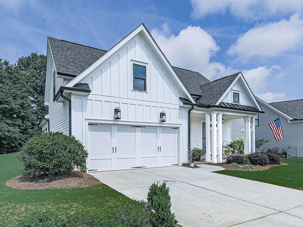 modern farmhouse style home featuring a garage, a front yard, and covered porch