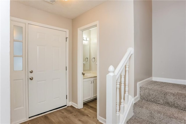 foyer with light wood finished floors and baseboards