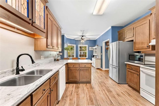 kitchen with ceiling fan, sink, light hardwood / wood-style flooring, kitchen peninsula, and appliances with stainless steel finishes