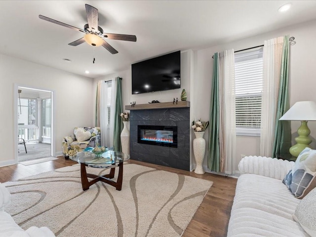 living area featuring ceiling fan, recessed lighting, a fireplace, wood finished floors, and baseboards