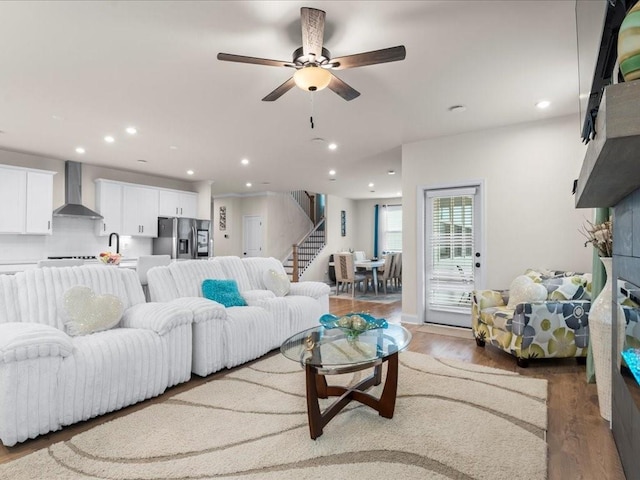 living room featuring stairway, wood finished floors, a ceiling fan, and recessed lighting