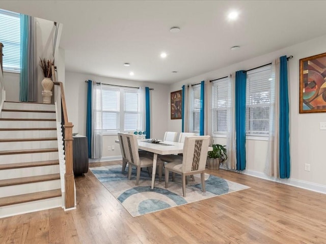 dining space with recessed lighting, light wood-style flooring, baseboards, and stairs