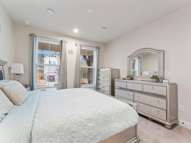 bedroom with recessed lighting, light carpet, and baseboards