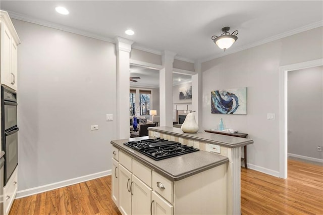 kitchen featuring black appliances, white cabinets, crown molding, and light wood-type flooring