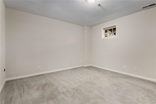 spare room featuring carpet, visible vents, and baseboards