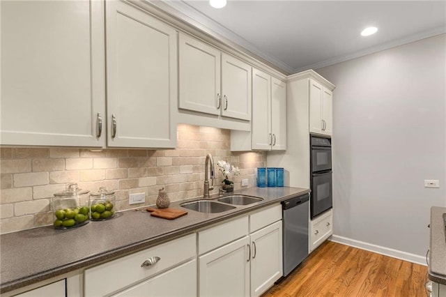 kitchen with light wood-style flooring, dobule oven black, a sink, tasteful backsplash, and stainless steel dishwasher