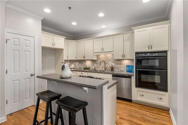 kitchen with ornamental molding, dobule oven black, a sink, light wood-style floors, and dishwasher