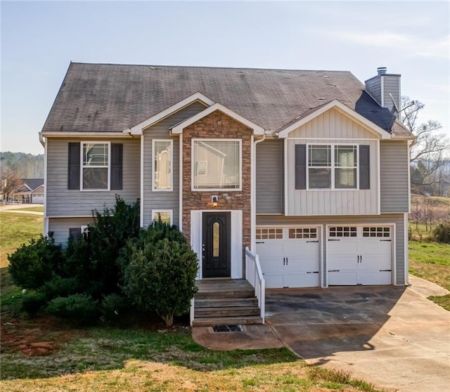 view of front of house featuring board and batten siding, a shingled roof, concrete driveway, a chimney, and a garage