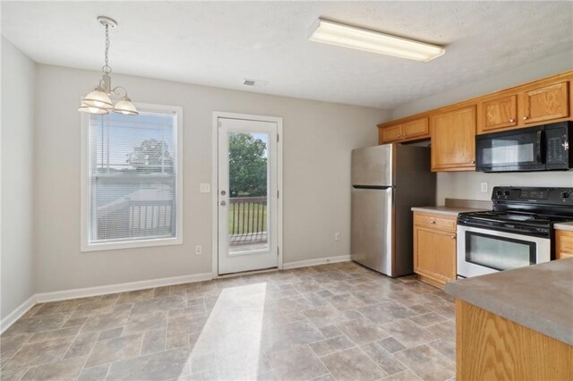 kitchen featuring hanging light fixtures, stone finish floor, baseboards, and stainless steel appliances