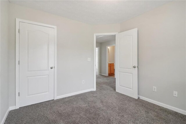 unfurnished bedroom with baseboards and carpet floors