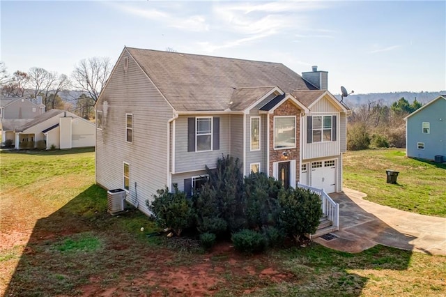 view of front of property featuring central air condition unit, driveway, a front lawn, a garage, and a chimney