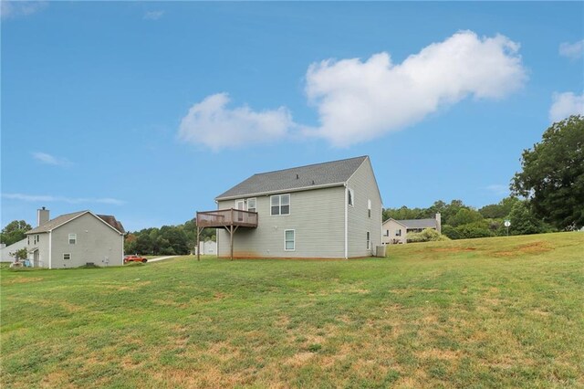 back of house with a deck and a yard
