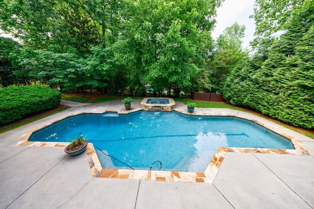 view of pool with a patio, fence, and a pool with connected hot tub