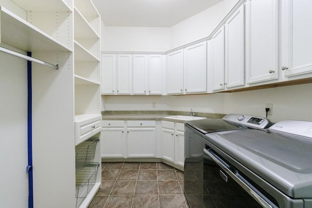 laundry room with washer and clothes dryer, tile patterned flooring, a sink, and cabinet space