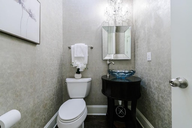 bathroom featuring a sink, toilet, and baseboards