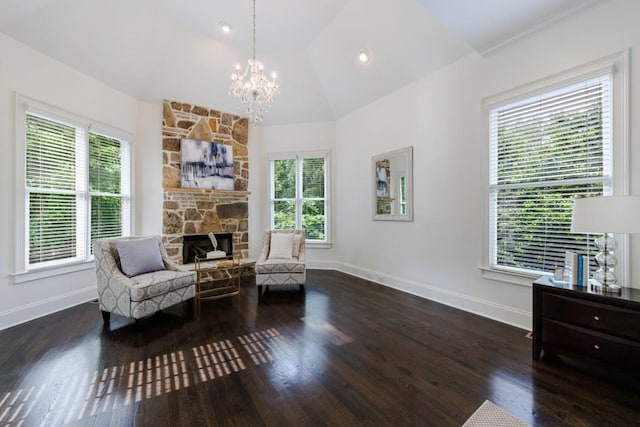 sitting room featuring a fireplace, vaulted ceiling, a wealth of natural light, and wood finished floors