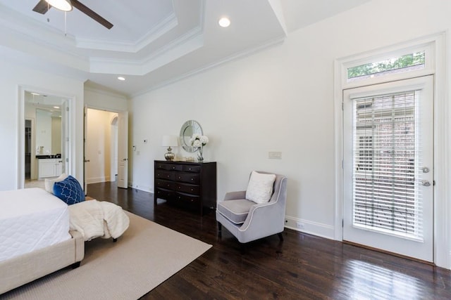 bedroom with access to exterior, a tray ceiling, multiple windows, and wood finished floors