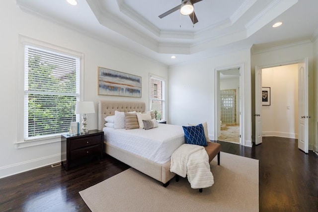 bedroom with baseboards, a tray ceiling, dark wood finished floors, and ornamental molding