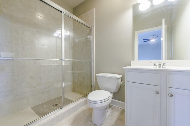 bathroom with toilet, vanity, baseboards, a shower stall, and tile patterned floors