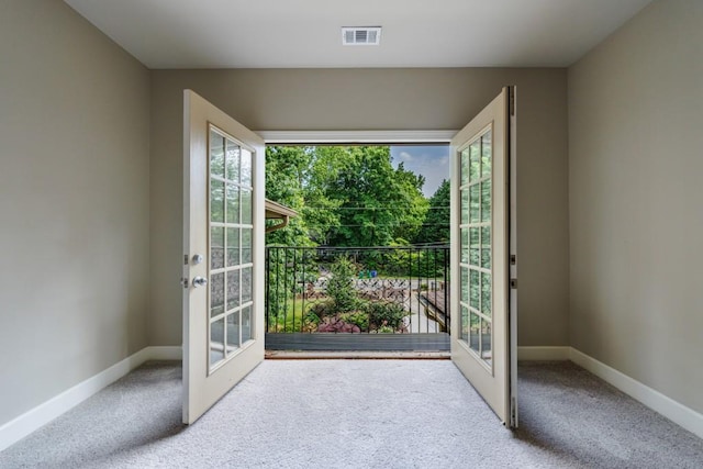 doorway with carpet floors, french doors, visible vents, and baseboards