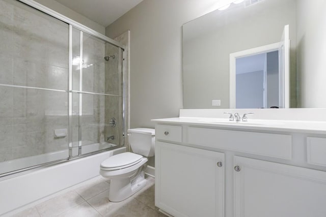 bathroom featuring vanity, shower / bath combination with glass door, tile patterned flooring, and toilet