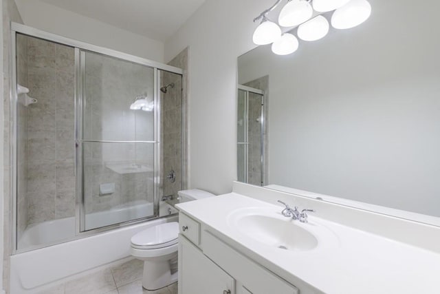 bathroom with tile patterned flooring, shower / bath combination with glass door, vanity, and toilet