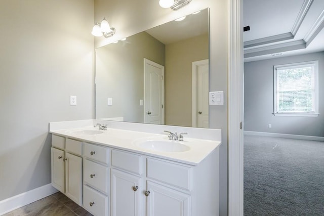 bathroom featuring crown molding, a sink, baseboards, and double vanity