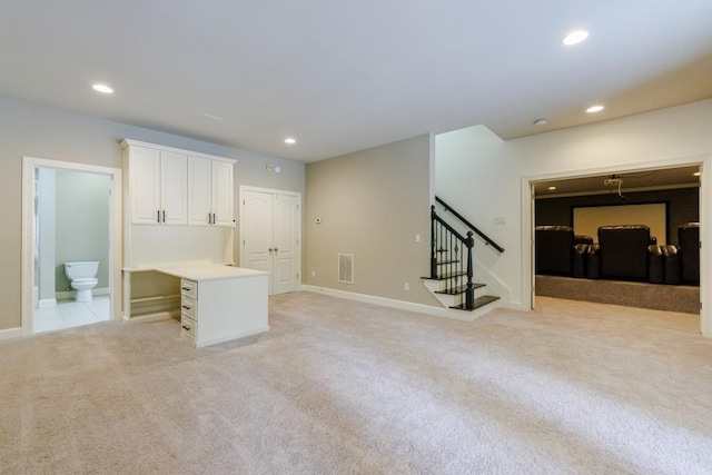 interior space with recessed lighting, light colored carpet, visible vents, baseboards, and stairway