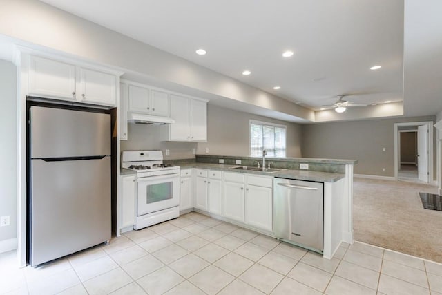 kitchen featuring stainless steel appliances, light colored carpet, open floor plan, a sink, and a peninsula