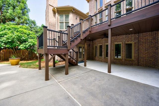 view of patio with stairs, fence, and a wooden deck