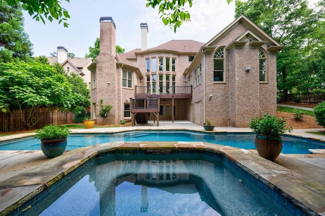 view of pool featuring a deck, an in ground hot tub, fence, stairs, and a fenced in pool