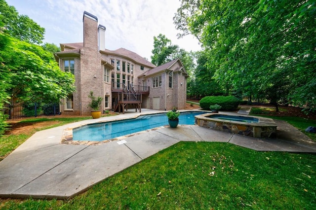 view of swimming pool featuring a pool with connected hot tub, a patio, stairway, and a lawn