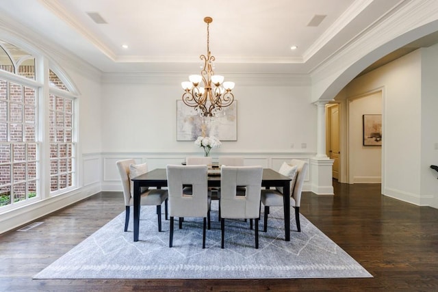 dining area with visible vents, arched walkways, a tray ceiling, ornate columns, and a decorative wall