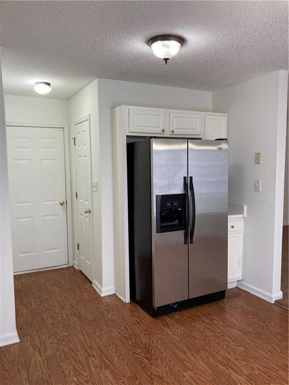 kitchen featuring white cabinetry, stainless steel fridge with ice dispenser, dark wood-type flooring, and a textured ceiling