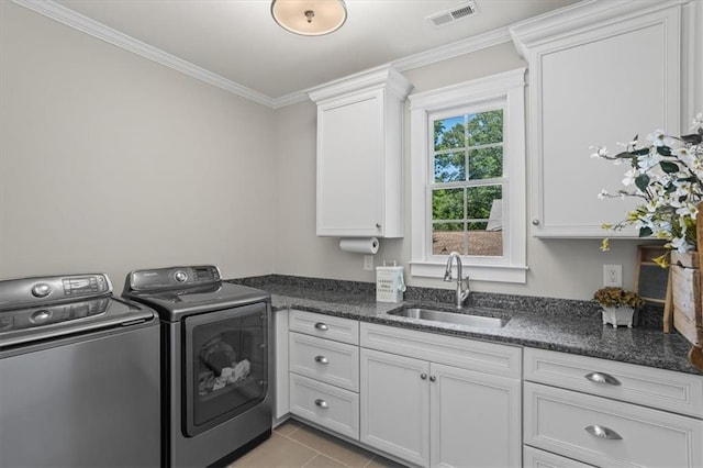 laundry area featuring sink, cabinets, light tile patterned floors, ornamental molding, and washer and clothes dryer