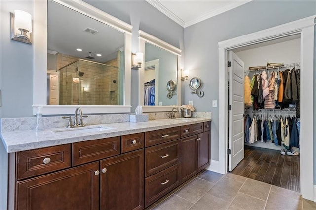 bathroom with ornamental molding, vanity, a shower with shower door, and tile patterned floors