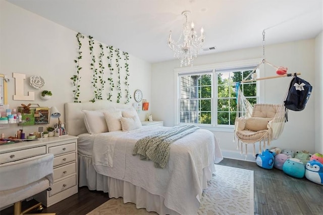 bedroom with dark hardwood / wood-style floors and a notable chandelier