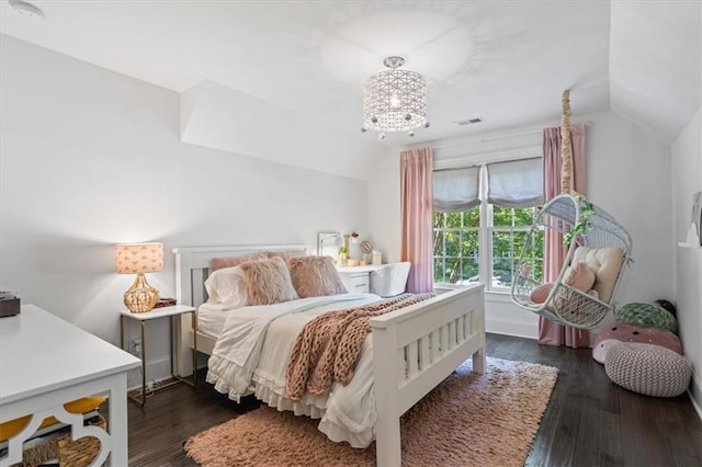 bedroom with dark hardwood / wood-style flooring, vaulted ceiling, and a chandelier