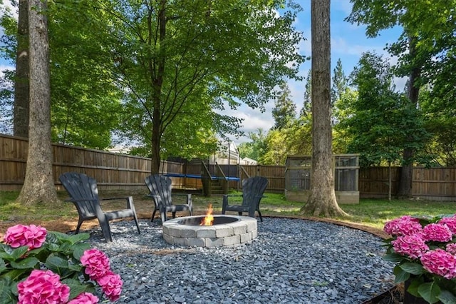 view of yard featuring a storage shed and a fire pit