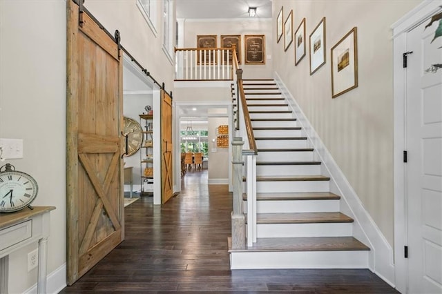 stairway with wood-type flooring and a barn door