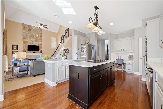 kitchen featuring decorative light fixtures, stainless steel appliances, a center island, and white cabinets