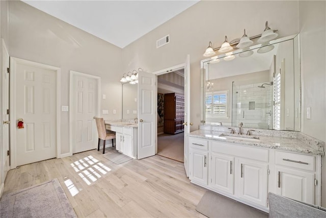 bathroom featuring hardwood / wood-style flooring, vanity, and a shower with shower door