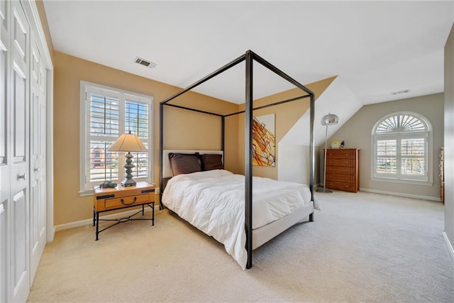 carpeted bedroom with vaulted ceiling and a closet