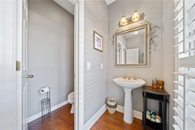 bathroom with hardwood / wood-style flooring and toilet